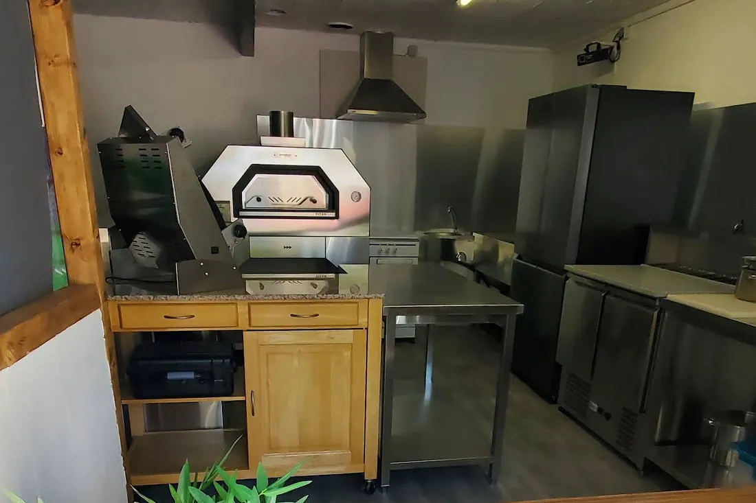 L’intérieur de Pizza Lanka : le four à pizza, les plans de travail et le comptoir en bois